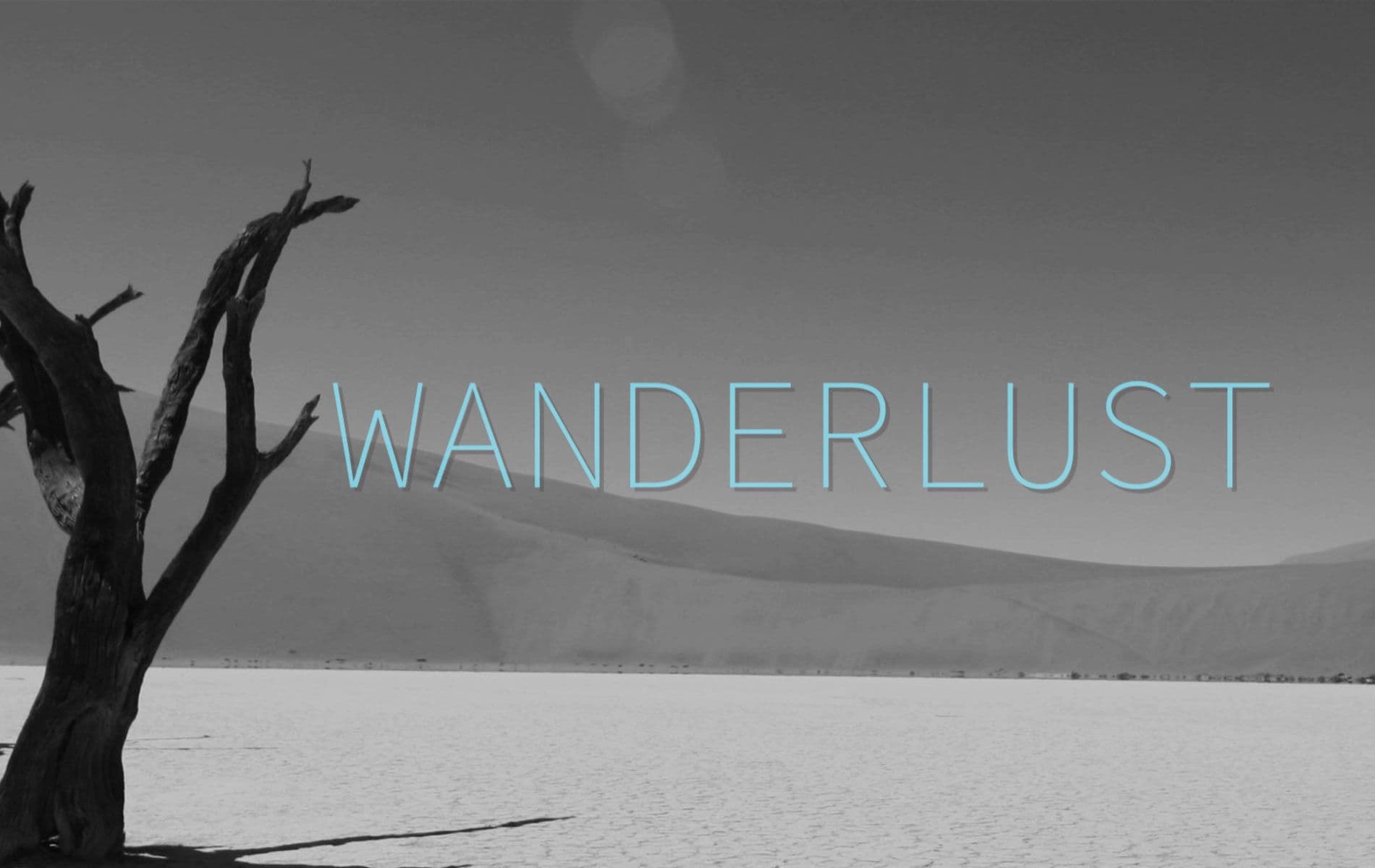 A black and white image of a barren tree in the Kalahari dessert with blue text that reads Wanderlust