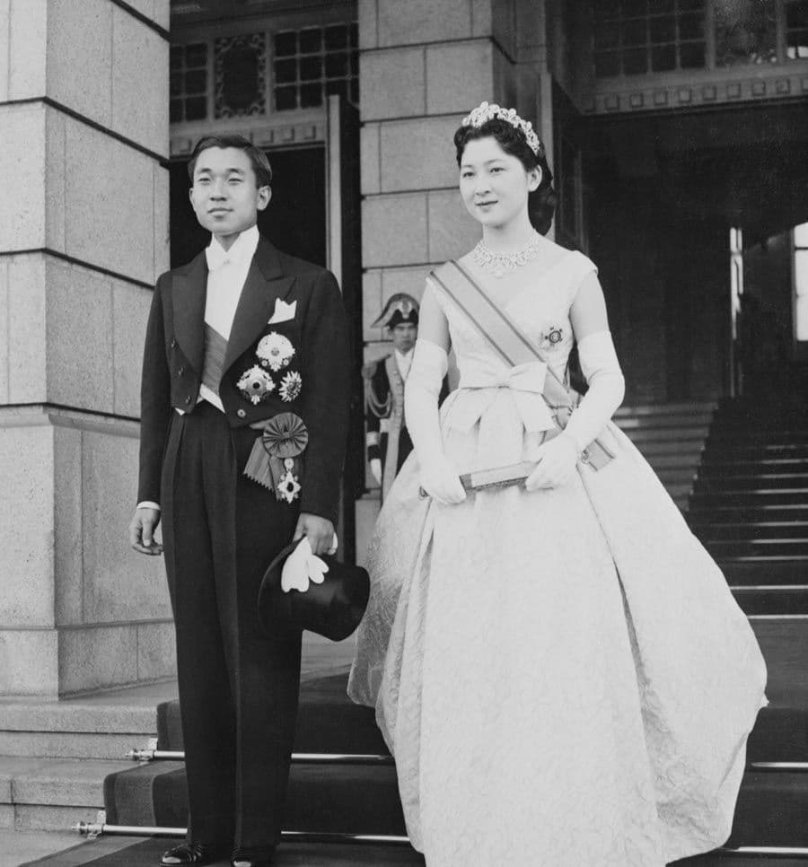 Following their wedding ceremony, then Japanese Crown Prince Akihito and his bride, the former Michiko Shoda, pose together before beginning a triumphant drive through the streets of Tokyo, April 10, 1959. The couple wore traditional Japanese costumes for the actual wedding ceremony. Photo: Bettmann / Contributor/ Getty Images