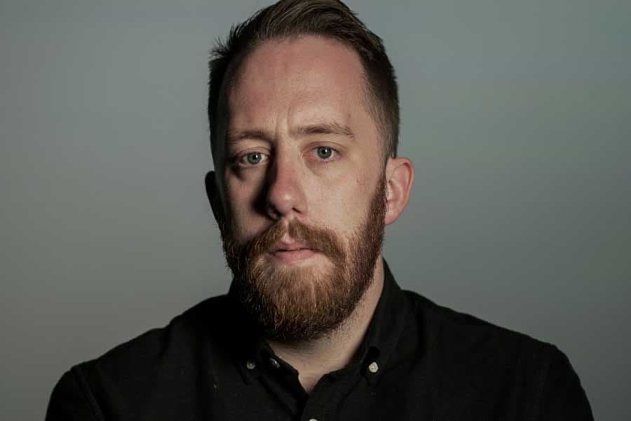 Justin Ling looking grim, wearing a black shirt.