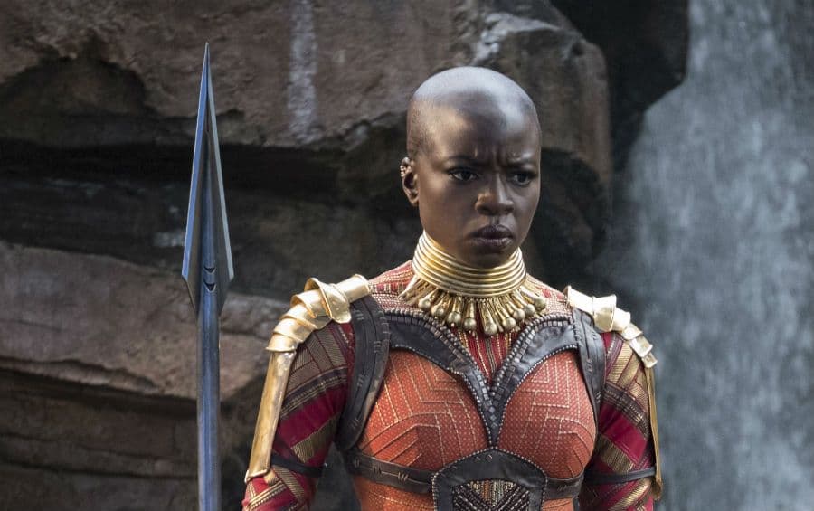 Warrior from black panther clad in red armour, holding spear.