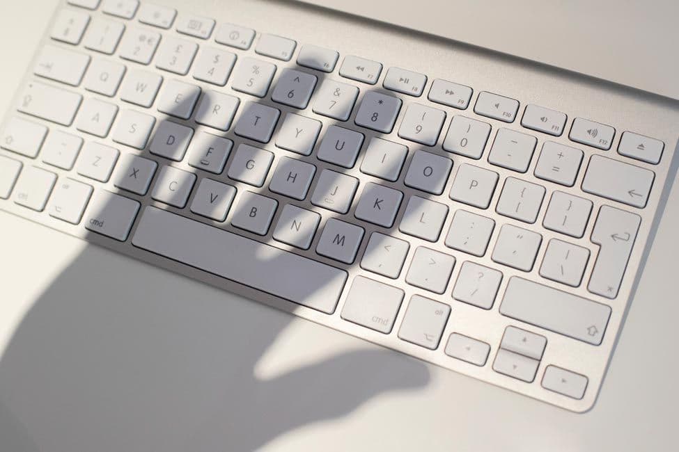 Computer Keyboard with shadow illustrating potential for scams and fraud.