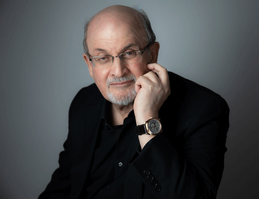 Salman Rushdie resting his chin on his hand.