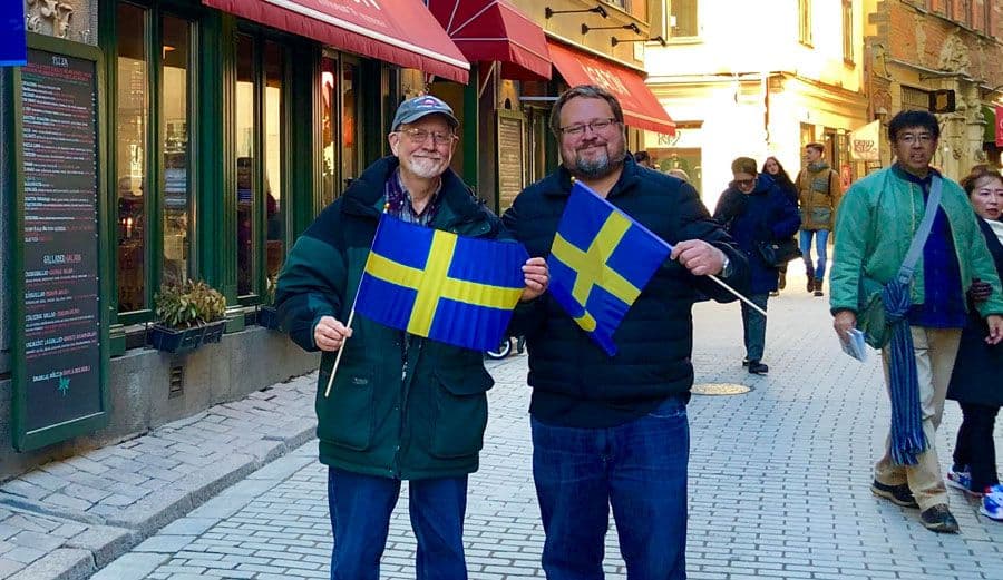 Tim Johnson and his father each hold a Swedish flag during a visit to the country.